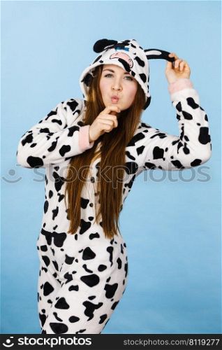 Happy teenage girl in funny nightclothes, pajamas cartoon style making silly face, positive face expression, studio shot on blue.. Woman wearing pajamas cartoon making silly face