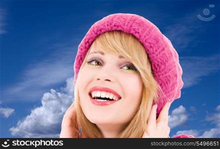 happy teenage girl in hat over winter sky