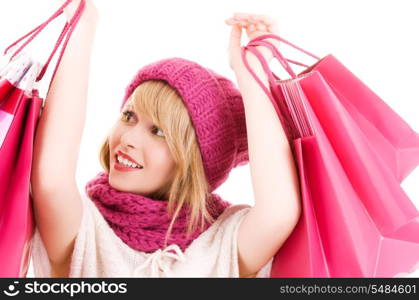 happy teenage girl in hat with pink shopping bags