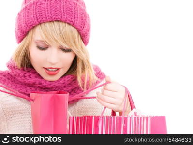 happy teenage girl in hat with pink shopping bags