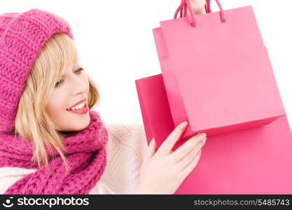 happy teenage girl in hat with pink shopping bags