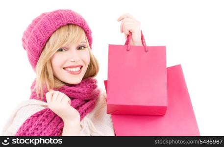 happy teenage girl in hat with pink shopping bags