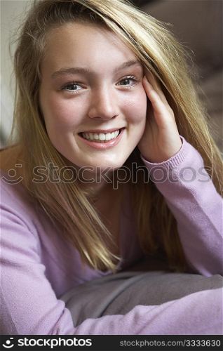 Happy Teenage Girl Sitting In Bedroom