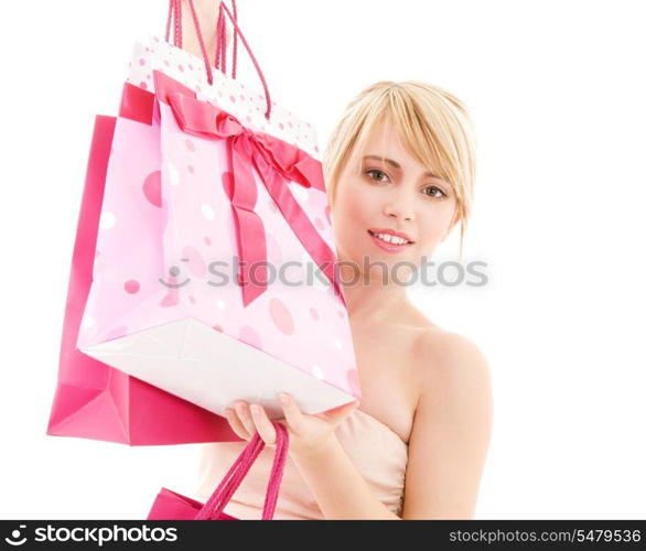 happy teenage girl with pink shopping bags