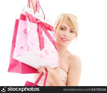 happy teenage girl with pink shopping bags