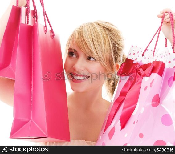 happy teenage girl with pink shopping bags
