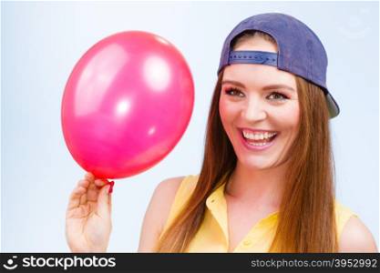 Happy teenage girl with red balloon.. Joy and fun. Beauty smiling teenage girl with red pink balloon. Young charming trendy woman in fashion clothes against blue background.