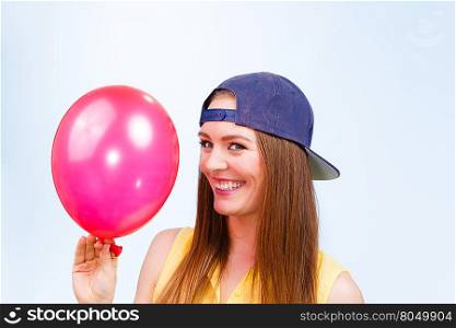 Happy teenage girl with red balloon.. Joy and fun. Beauty smiling teenage girl with red pink balloon. Young charming trendy woman in fashion clothes against blue background.
