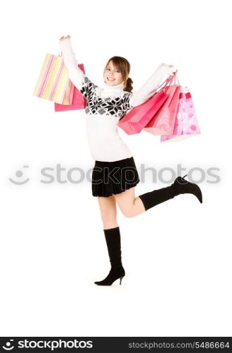 happy teenage girl with shopping bags over white