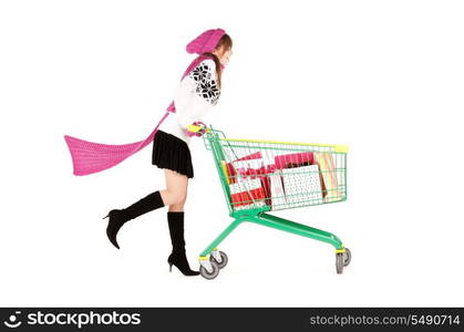 happy teenage girl with shopping cart over white