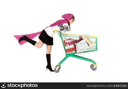 happy teenage girl with shopping cart over white