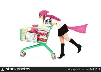 happy teenage girl with shopping cart over white