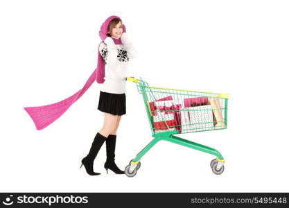 happy teenage girl with shopping cart over white