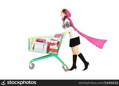 happy teenage girl with shopping cart over white