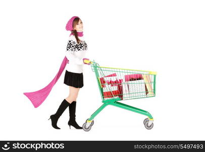 happy teenage girl with shopping cart over white