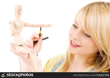 happy teenage girl with wooden model dummy over white