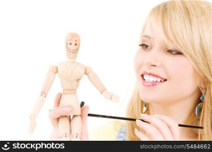 happy teenage girl with wooden model dummy over white