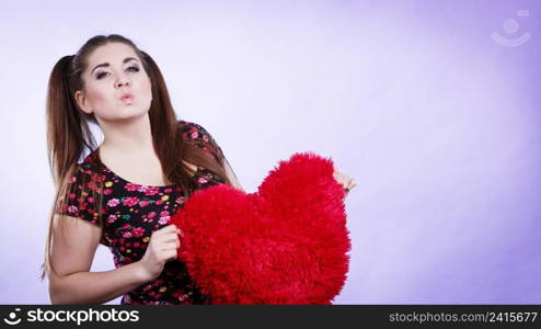 Happy teenage woman holding heart shaped pillow. Valentines day gift ideas concept.. Happy woman holding heart shaped pillow