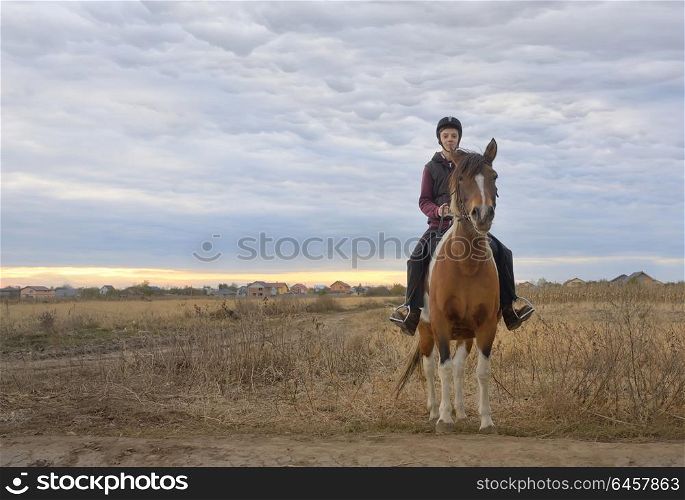 Happy teenager boy with horse on field