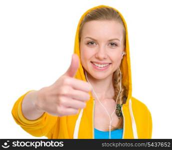 Happy teenager girl in earphones showing thumbs up