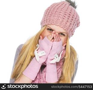 Happy teenager girl in winter hat and scarf closing face