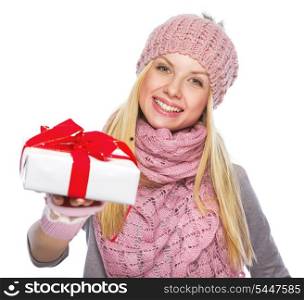 Happy teenager girl in winter hat and scarf giving presenting box