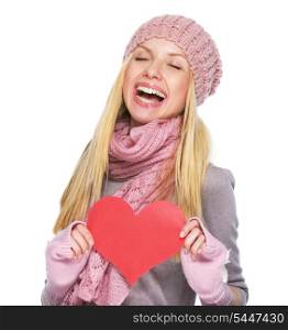 Happy teenager girl in winter hat and scarf with heart shaped postcard