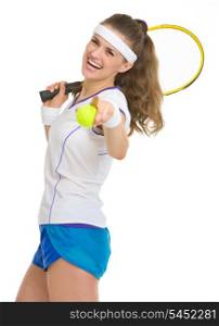 Happy tennis player with racket and ball pointing in camera