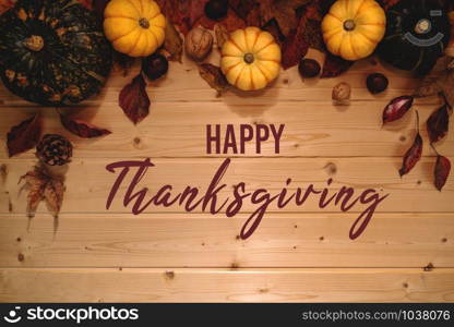 Happy Thanksgiving Day with pumpkin and nut on wooden background