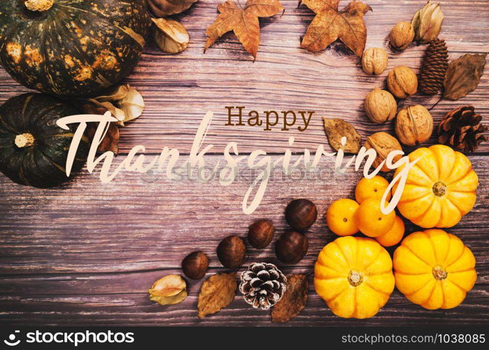 Happy Thanksgiving Day with pumpkin and nut on wooden table