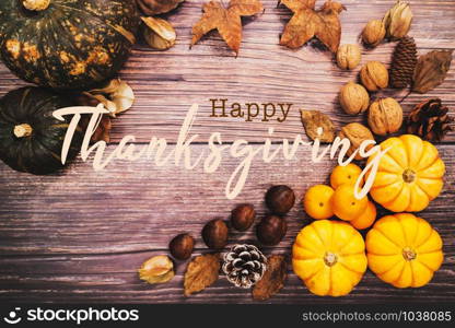 Happy Thanksgiving Day with pumpkin and nut on wooden table