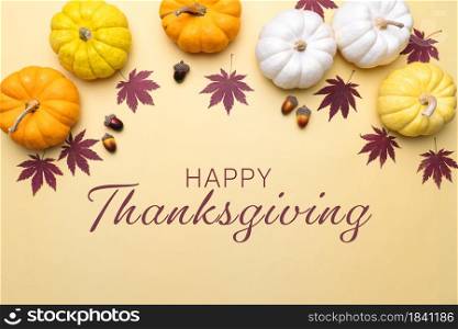 Happy Thanksgiving Day with pumpkin and nut on yellow background