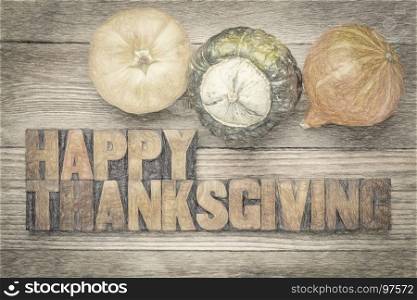 Happy Thanksgiving greeting card - text in vintage letterpress wood type blocks against rustic weathered wood with winter squash, digital charcoal painting effect