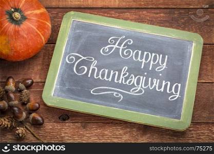 Happy Thanksgiving greeting card - white chalk text on a vintage slate blackboard with winter squash and acorn