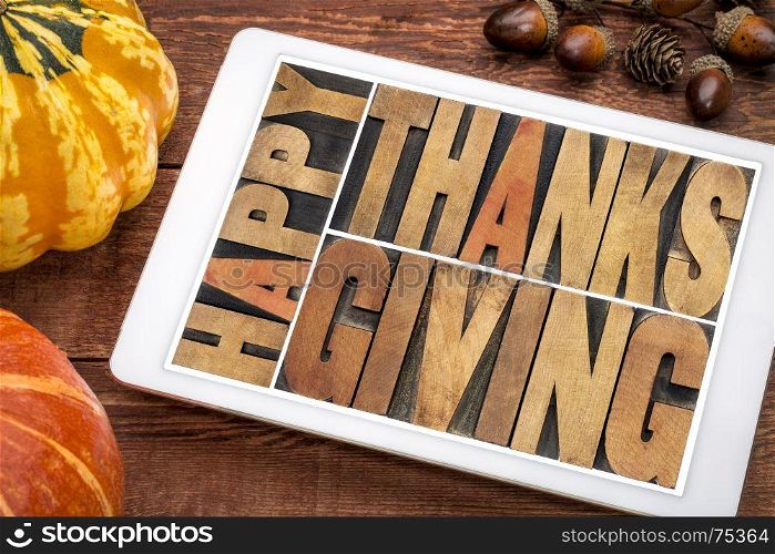 Happy Thanksgiving greeting card - word abstract in vintage letterpress wood type blocks on a digital tablet with a winter squash and acorn