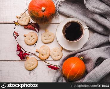 Happy Thanksgiving. Ripe pumpkins, autumn leaves and a cup of hot coffee. Preparing for the holidays. View from above, close-up. Congratulations to loved ones, family, relatives, friends, colleagues. Pumpkins, autumn leaves and a cup of coffee