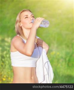 Happy tired woman drink water after workout in the park, enjoying training outdoors in sunny day, sportive and healthy lifestyle&#xA;