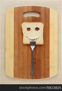 Happy toast with a fork in her mouth on a cutting board