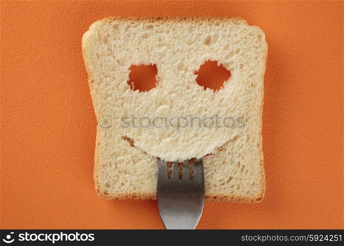 Happy toast with a fork in her mouth on a cutting board