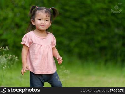 happy toddler girl in grass field
