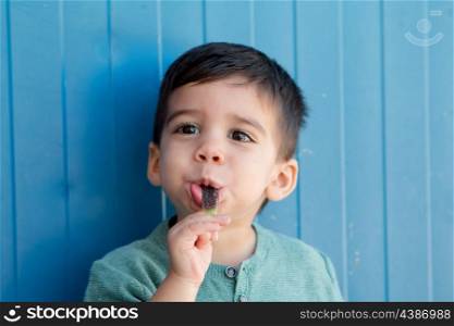 Happy toddler on the street eating a lollipop