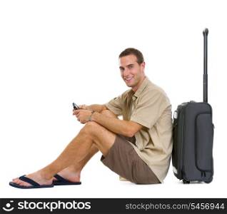 Happy tourist sitting near wheels bag