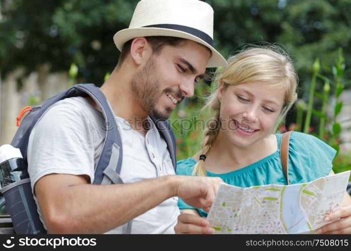 happy tourists searching location together on the map