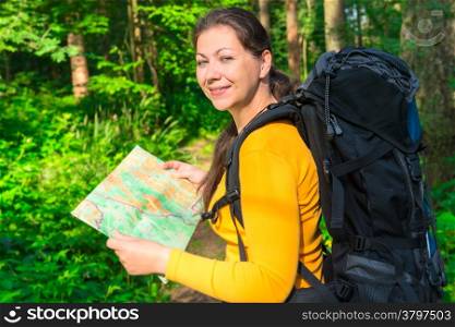 happy traveler with a map in the forest