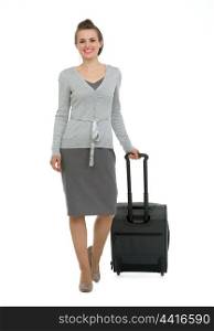 Happy traveling woman with suitcase making step forward