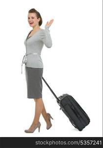 Happy traveling woman with suitcase waving hand