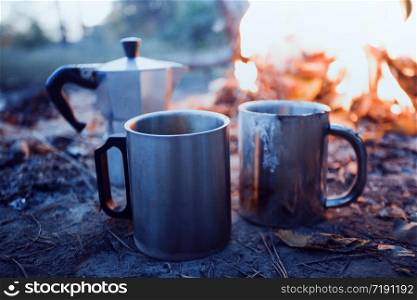 happy trip - bonfire and geyser coffee maker with cup in the foreground