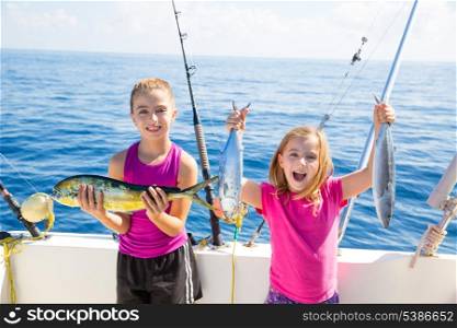 Happy tuna fisherwomen kid girls on boat with fishes trolling catch with dorado Mahi