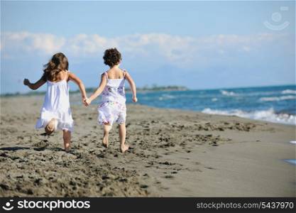 happy two little girls have fun and joy time at beautiful beach while running from joy