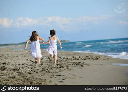 happy two little girls have fun and joy time at beautiful beach while running from joy